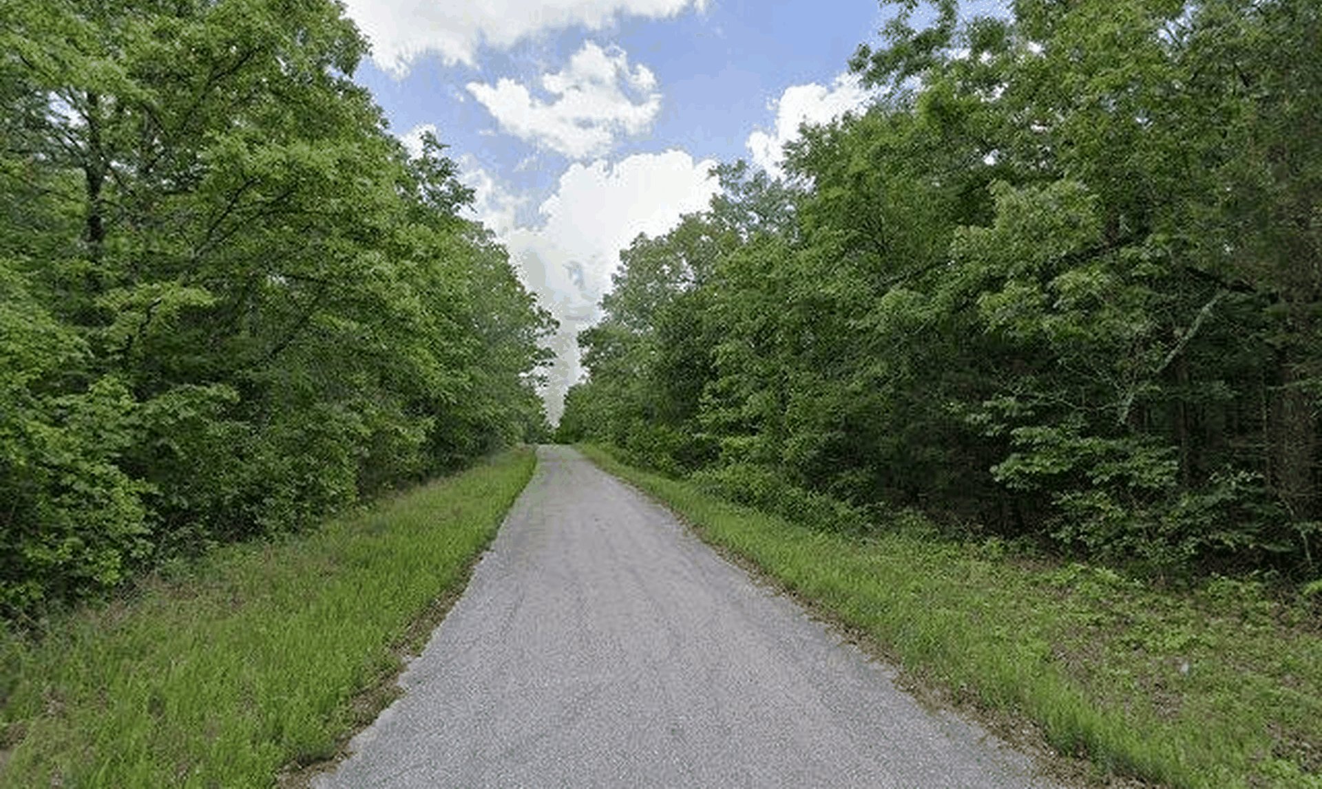 Street-level photo of the paved road through the Spring Addition subdivision where Lot 32 sits